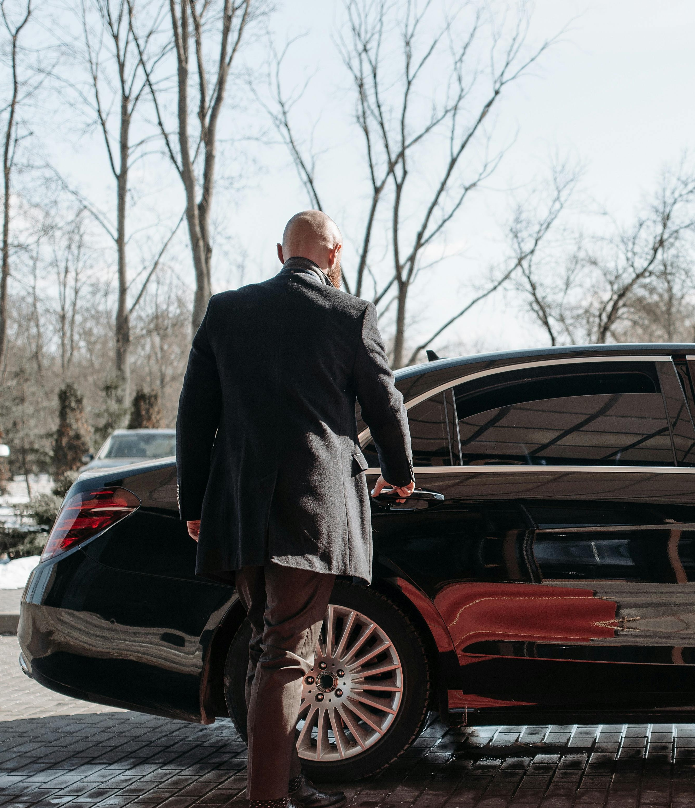 Executive protection professional beside a vehicle.